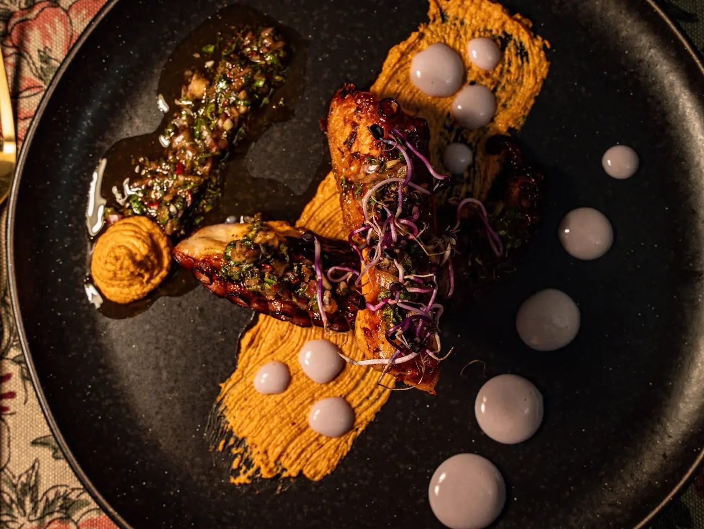 Pulpo glaseado a la brasa con crema de patata violeta y salsa romesco